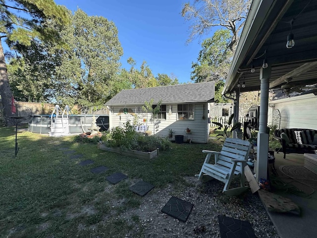 view of yard featuring an outbuilding and a fenced in pool