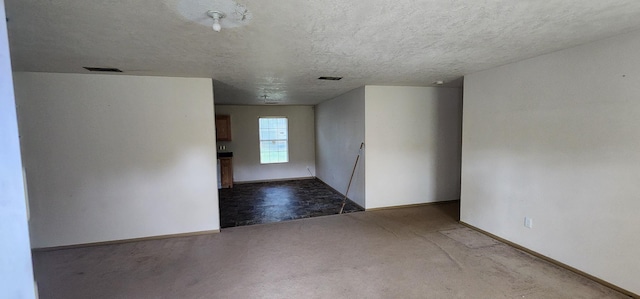 carpeted empty room with a textured ceiling