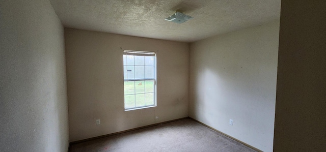 carpeted spare room with a textured ceiling