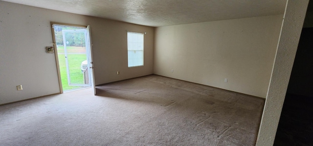 carpeted spare room with a textured ceiling