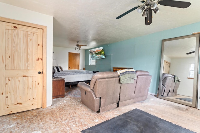 bedroom with ceiling fan and a textured ceiling