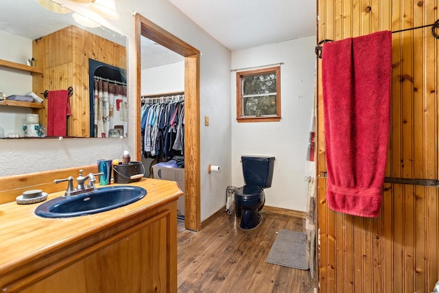 bathroom with wood-type flooring, vanity, and toilet