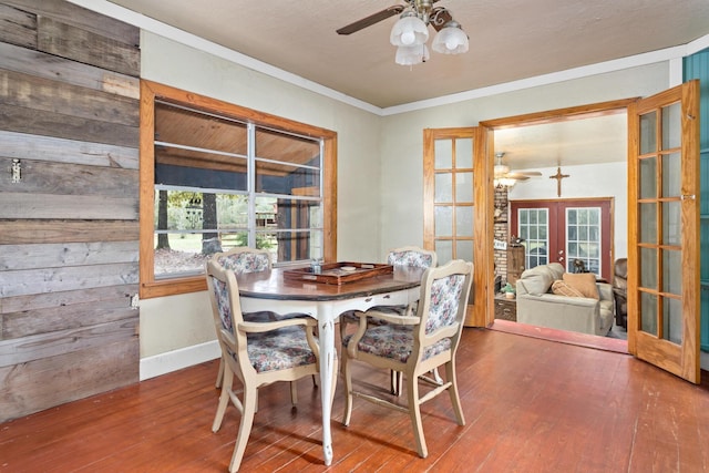 dining area featuring ceiling fan, french doors, wood-type flooring, and ornamental molding