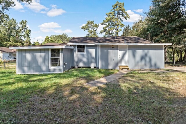 rear view of property with a lawn