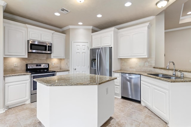 kitchen featuring white cabinets, sink, appliances with stainless steel finishes, light stone counters, and kitchen peninsula