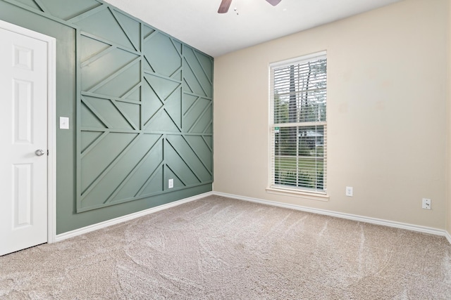 spare room featuring ceiling fan and carpet