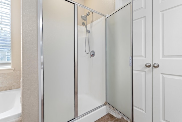 bathroom featuring tile patterned flooring and shower with separate bathtub