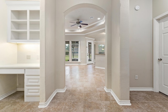 entrance foyer featuring ceiling fan, crown molding, and a tray ceiling