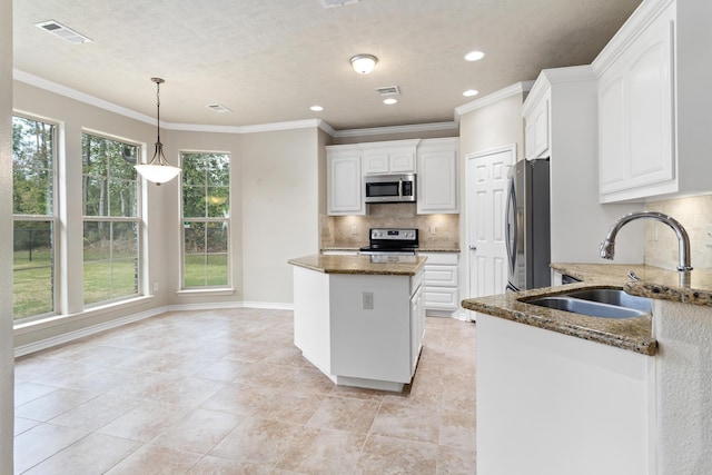 kitchen with dark stone counters, sink, decorative backsplash, appliances with stainless steel finishes, and white cabinetry