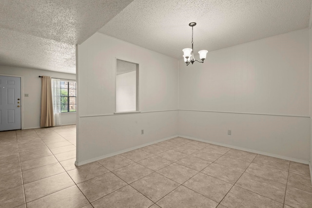 spare room with ornamental molding, a notable chandelier, a textured ceiling, and light tile patterned floors