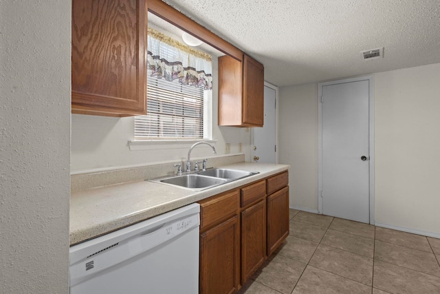 kitchen featuring brown cabinets, dishwasher, a textured ceiling, and a sink