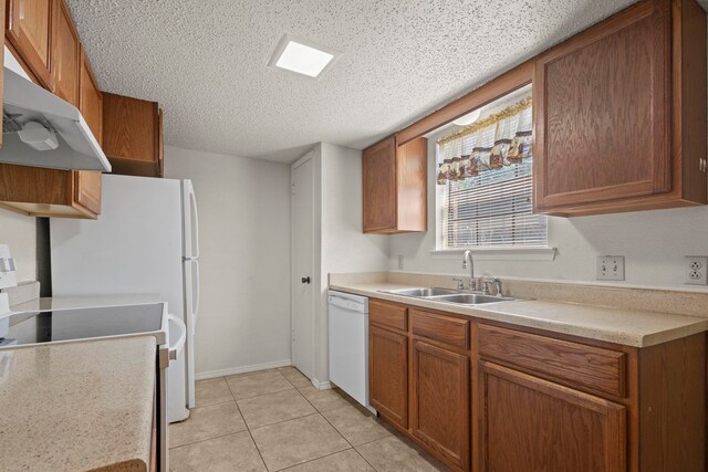 kitchen featuring under cabinet range hood, light countertops, a sink, white dishwasher, and a textured ceiling