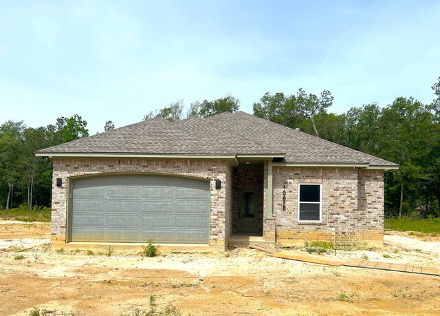 10675 Vinson St, Beaumont, TX 77713 - view of front of house featuring brick siding, a shingled roof, and a garage