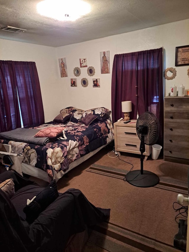 carpeted bedroom featuring a textured ceiling