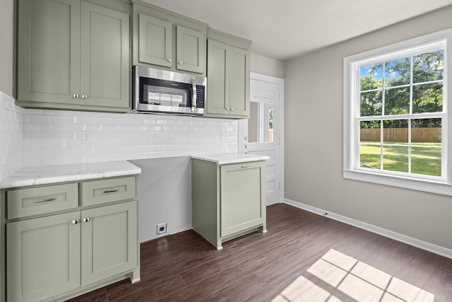 815 Central Dr, Beaumont, TX 77706 - kitchen with stainless steel microwave, dark wood finished floors, tasteful backsplash, baseboards, and light stone countertops