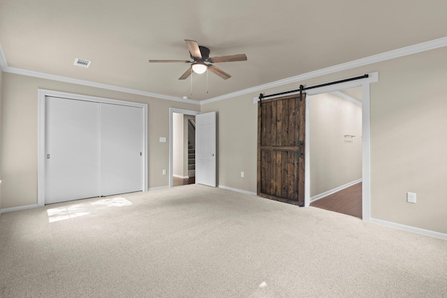 815 Central Dr, Beaumont, TX 77706 - unfurnished bedroom featuring crown molding, a barn door, carpet flooring, baseboards, and a closet