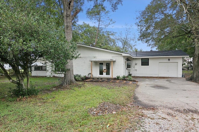 ranch-style house with french doors, a garage, and a front lawn