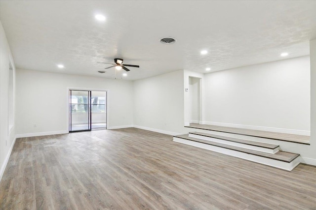 unfurnished room featuring ceiling fan, a textured ceiling, and light hardwood / wood-style flooring