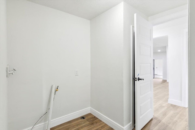 clothes washing area featuring light hardwood / wood-style flooring