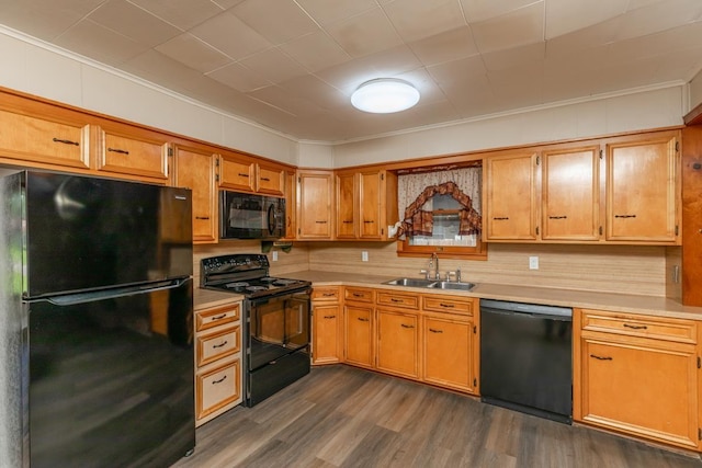 3012 Berry Ave, Groves, TX 77619 - kitchen featuring black appliances, light countertops, dark wood finished floors, ornamental molding, and brown cabinetry