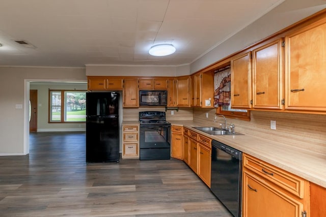 3012 Berry Ave, Groves, TX 77619 - kitchen featuring black appliances, light countertops, dark wood-style flooring, crown molding, and brown cabinets