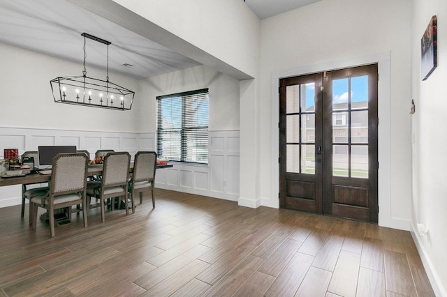 entryway featuring french doors, dark hardwood / wood-style floors, and a notable chandelier