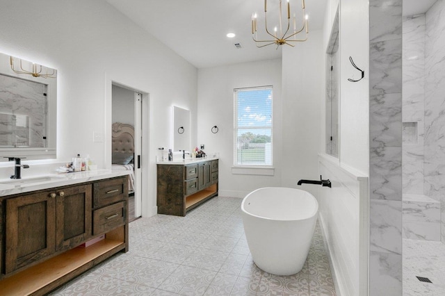 bathroom with a washtub, vanity, and a chandelier