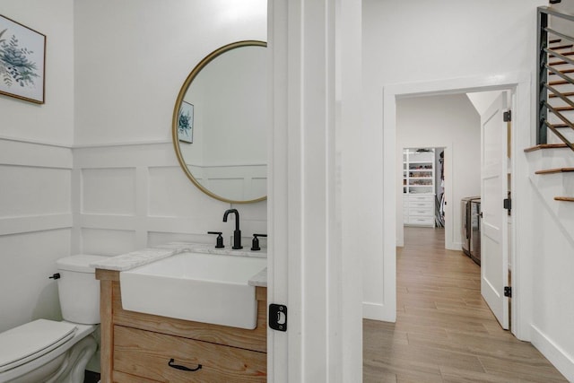 bathroom with hardwood / wood-style flooring, vanity, and toilet