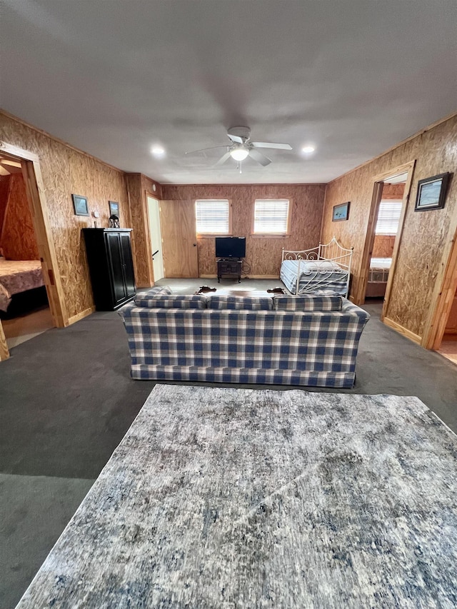 carpeted living room with a ceiling fan and baseboards