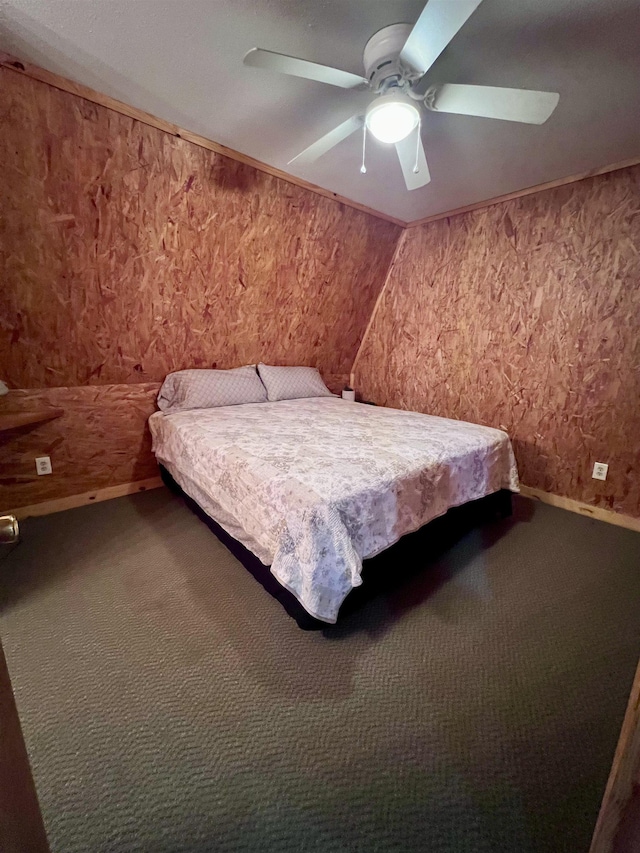 carpeted bedroom with a ceiling fan, vaulted ceiling, ornamental molding, and baseboards