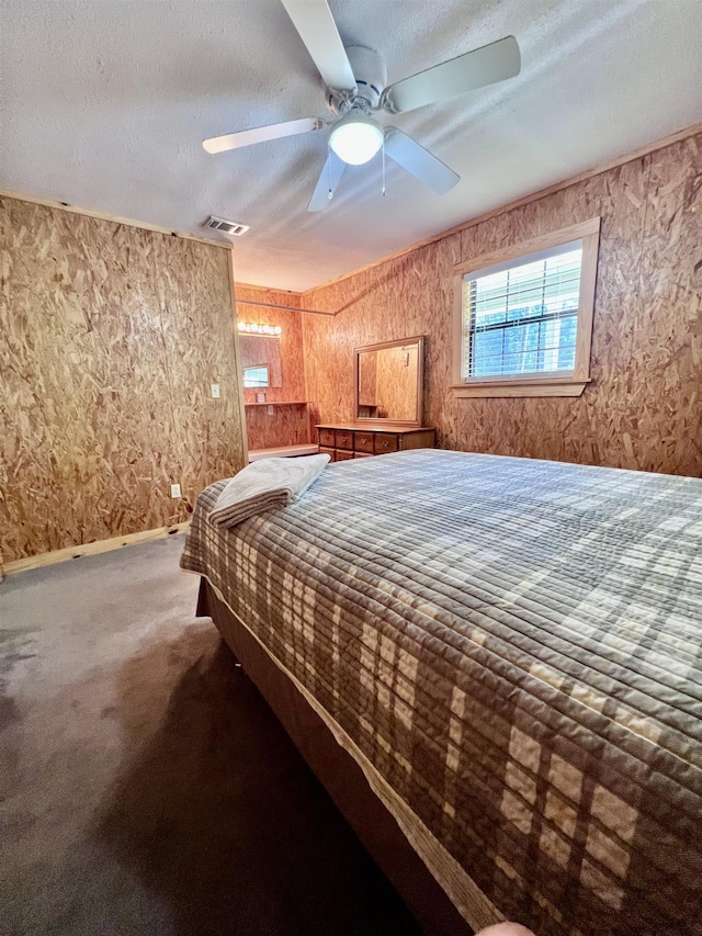 unfurnished bedroom with a textured ceiling, carpet, visible vents, and a ceiling fan