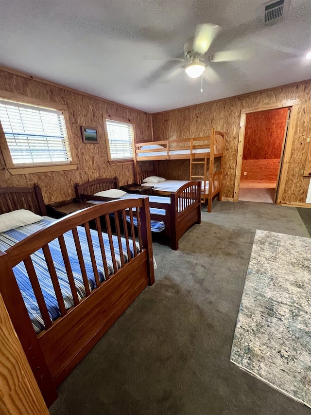 bedroom with a textured ceiling, carpet floors, and visible vents