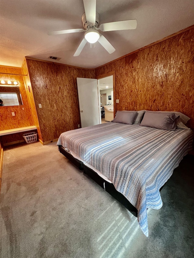 unfurnished bedroom with a ceiling fan, visible vents, carpet flooring, and ornamental molding