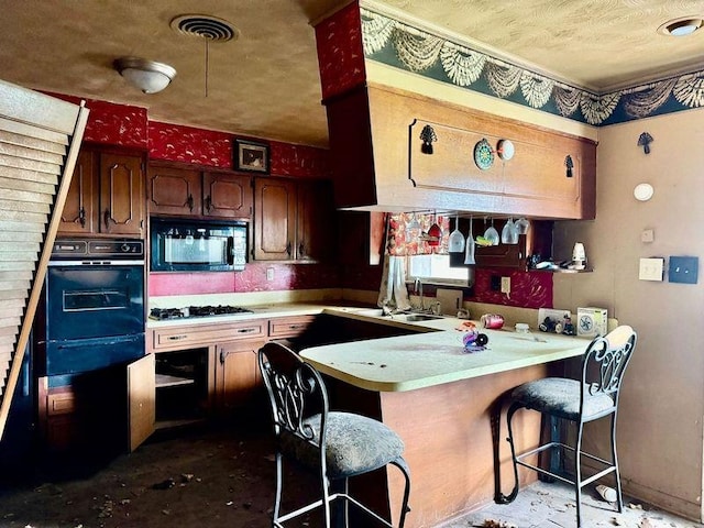 733 Phyllis Ave, Port Arthur, TX 77640 - kitchen featuring black appliances, a peninsula, light countertops, a breakfast bar area, and a sink