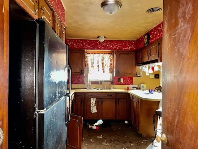 733 Phyllis Ave, Port Arthur, TX 77640 - kitchen featuring freestanding refrigerator, a sink, unfinished concrete floors, and light countertops