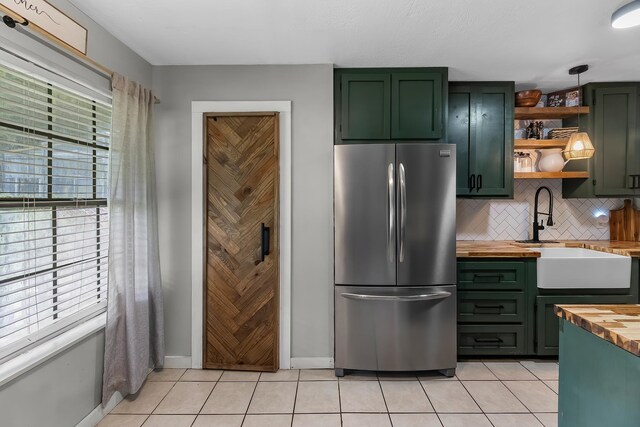 1432 W Palm Dr, Winnie, TX 77665 - kitchen with freestanding refrigerator, wooden counters, and green cabinets