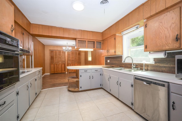 kitchen with sink, hanging light fixtures, an inviting chandelier, stainless steel dishwasher, and black oven