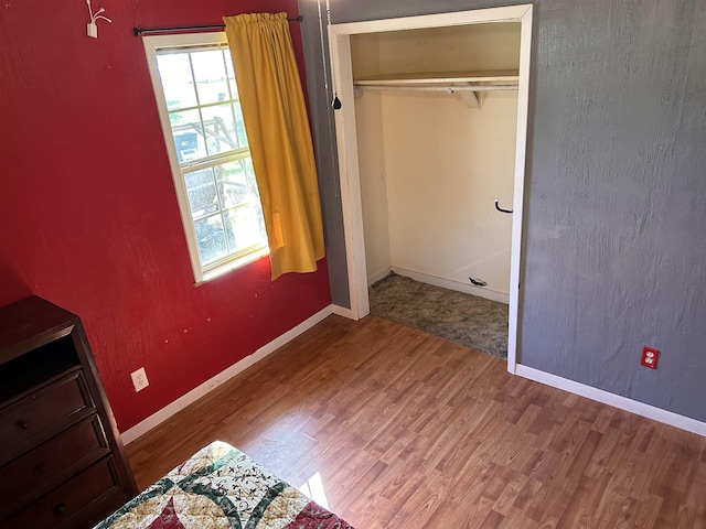 unfurnished bedroom featuring a closet and hardwood / wood-style floors