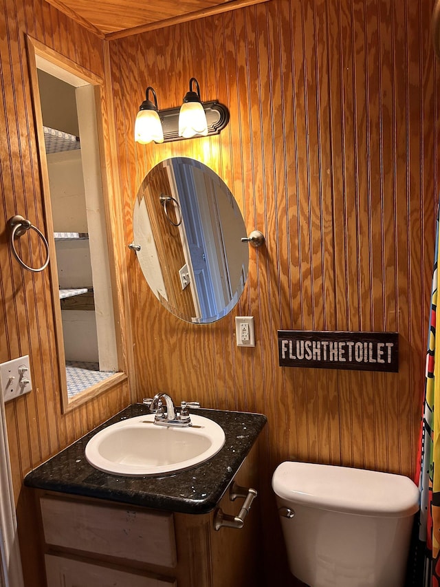 bathroom featuring toilet, wooden ceiling, sink, and wooden walls