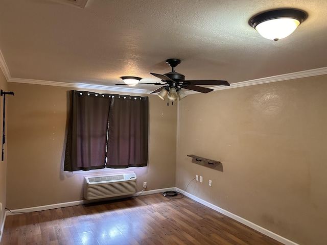 spare room featuring ceiling fan, dark wood-type flooring, a wall mounted AC, crown molding, and a textured ceiling