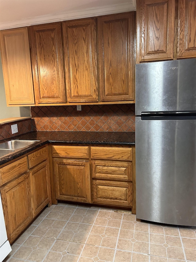 kitchen featuring sink, stainless steel refrigerator, and light tile patterned flooring