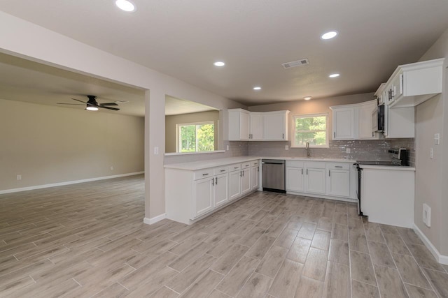 319 Pinemont Dr, Beaumont, TX 77659 - kitchen featuring decorative backsplash, baseboards, open floor plan, light wood-style flooring, and appliances with stainless steel finishes