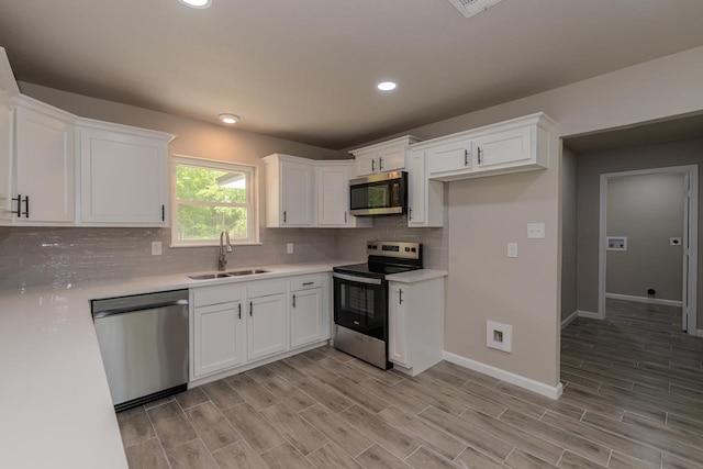 319 Pinemont Dr, Beaumont, TX 77659 - kitchen featuring light countertops, white cabinets, a sink, backsplash, and stainless steel appliances