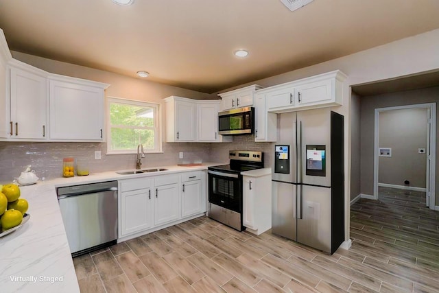 319 Pinemont Dr, Beaumont, TX 77659 - kitchen with light countertops, white cabinetry, appliances with stainless steel finishes, and a sink