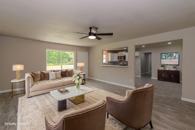 319 Pinemont Dr, Beaumont, TX 77659 - living room featuring baseboards, a ceiling fan, a textured ceiling, and wood finished floors