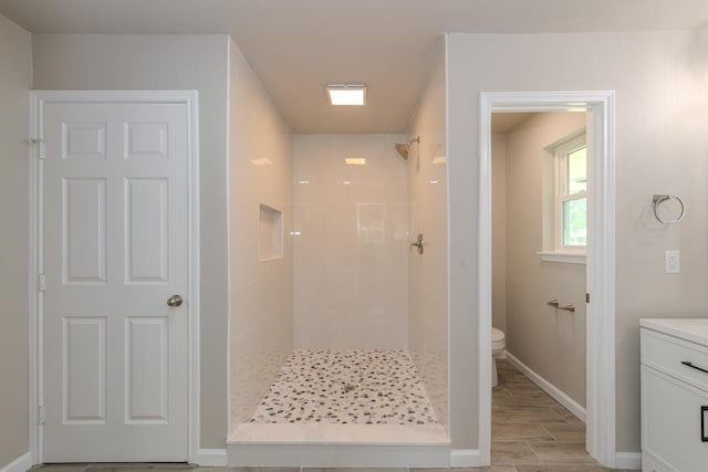 319 Pinemont Dr, Beaumont, TX 77659 - bathroom featuring vanity, wood finished floors, toilet, baseboards, and a shower stall
