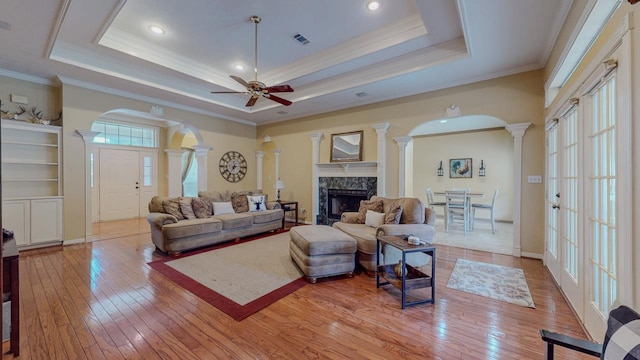 7640 Merion Dr, Beaumont, TX 77707 - living room featuring decorative columns, a ceiling fan, a high end fireplace, light wood-type flooring, and arched walkways