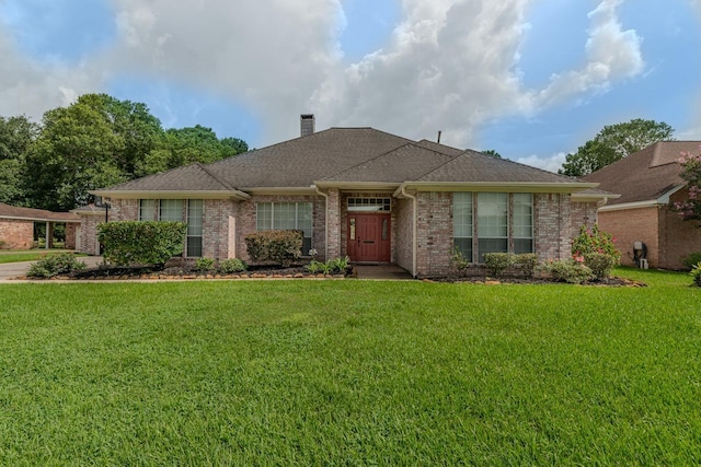 7640 Merion Dr, Beaumont, TX 77707 - view of front of home with a front yard, a chimney, and brick siding