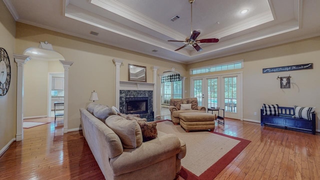 7640 Merion Dr, Beaumont, TX 77707 - living area with ornate columns, a tray ceiling, a high end fireplace, hardwood / wood-style flooring, and ornamental molding