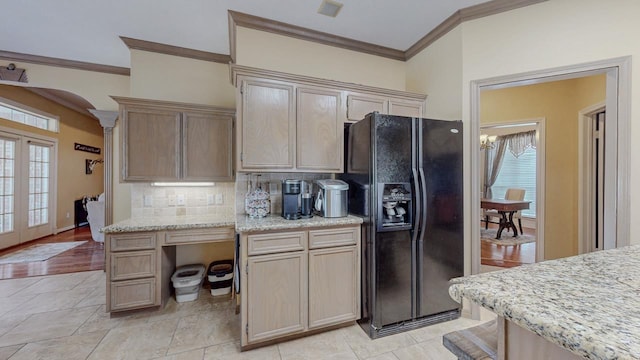 7640 Merion Dr, Beaumont, TX 77707 - kitchen with black fridge, crown molding, decorative backsplash, healthy amount of natural light, and light stone countertops